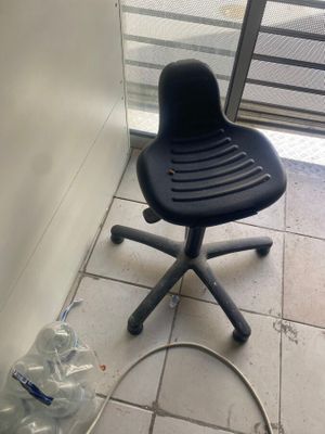 a black chair and a hose on the floor in front of a door