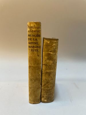 deux vieux livres posés l'un sur l'autre sur une surface blanche