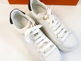 pair of white sneakers with black laces on a white surface