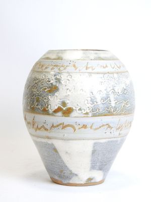 a white and blue vase sitting on a white surface