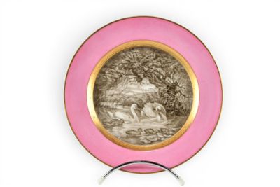 une assiette rose ornée d'un dessin, posée sur un socle