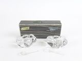 une paire de bougeoirs en verre transparent en forme de cœur, présentés dans un coffret cadeau