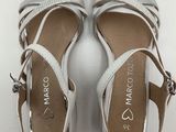white leather sandals with silver straps on a white surface