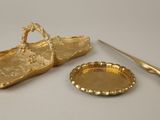 a gold plate and a pair of scissors next to it