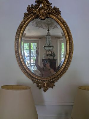 a mirror on the wall reflecting a person taking a picture