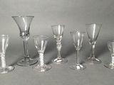 several empty wine glasses are lined up on a gray surface