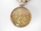 a medal with a ribbon around it that has a picture of a man on a horse