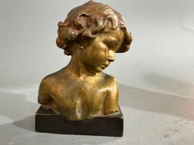 une statue en bronze représentant un jeune garçon, posée sur un socle en marbre
