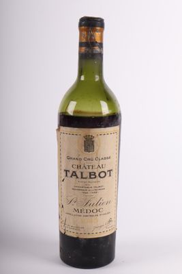 an old bottle of wine sitting on top of a white table
