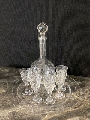 an image of a clear glass decanter and four glasses on a table