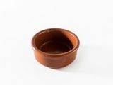 un petit bol marron posé sur une table blanche