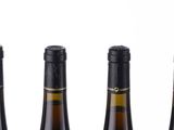 three bottles of wine sitting next to each other on a white surface