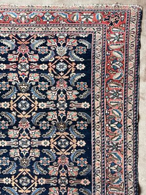 un tapis persan ancien aux couleurs bleu et rouge
