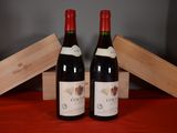 two bottles of red wine sitting next to each other on a table