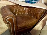 a brown leather chair that is sitting in a pile of boxes