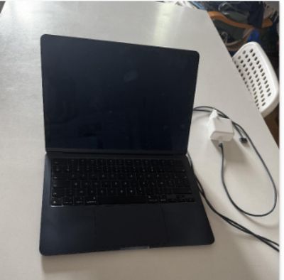 un ordinateur portable posé sur une table avec un chargeur