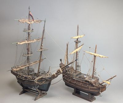 une paire de maquettes de bateaux en bois posées sur un socle en bois
