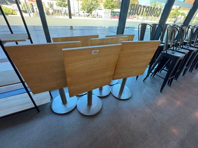 Des tables et des chaises sont alignées dans une grande salle donnant sur l'océan.