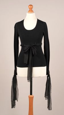 le haut d'un torse de mannequin portant un haut noir et du tulle noir