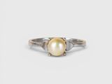 un gros plan d'une bague en perle sur fond blanc