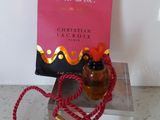 un flacon de parfum à côté d'un sac rose