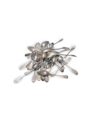 une pile de cuillères et de fourchettes en argent posées sur une surface blanche