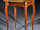 a small wooden table with a marble top on a grey surface