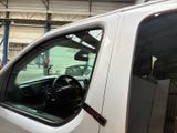 a white truck parked in a garage with its door open