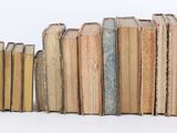 many books stacked on top of each other on a table