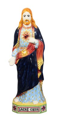 La statue de Jésus porte une couronne et tient une croix.