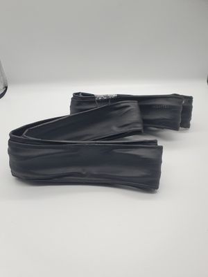 une paire de chaussures en cuir noir posées sur une surface blanche, avec une lampe en arrière-plan