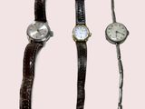 trois modèles de montres différents sur fond rose