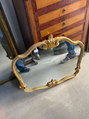 a mirror that is sitting on the floor in front of a dresser