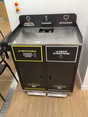 two trash bins that are sitting on the floor