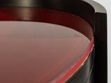 a close up of a red table with a black base