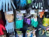 many different colored gardening gloves on display in a store