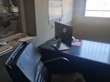 a black leather chair in front of a desk in an office