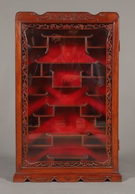 une vieille vitrine en bois avec une porte en verre rouge