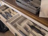 a lot of utensils in a drawer on the counter
