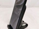 the back of a cell phone on a stand on a white surface