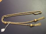 two gold tassels with tassels on a black surface