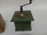 a small coffee grinder sitting on a table next to a wooden box