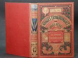 an old book with a red cover sitting on top of a table