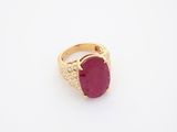 an oval ruby and diamond ring on a white surface