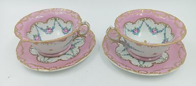 deux tasses à thé roses et dorées avec leurs soucoupes, posées sur une surface blanche
