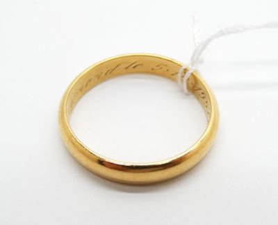 un gros plan d'une bague en or avec un fil, posée sur une surface blanche