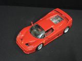 a red toy car that is sitting on a black surface