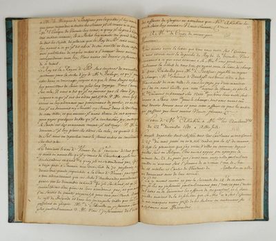 un livre ouvert avec une écriture dessus, posé sur une table