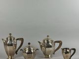 an image of a silver tea set with four cups and a saucer