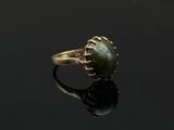 une bague en or avec une pierre de jade verte au centre